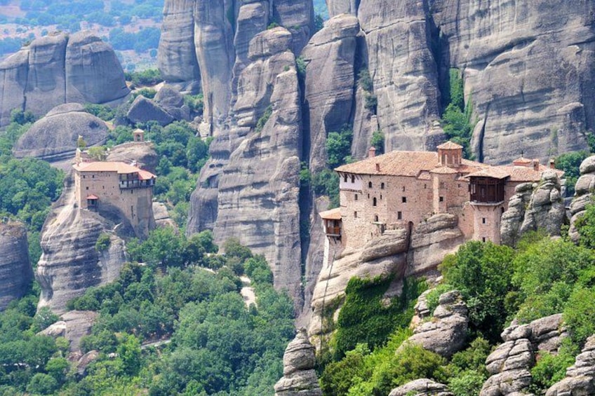Un monastero arroccato su una scogliera rocciosa, circondato da una vegetazione rigogliosa. 2