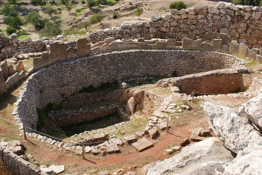 An ancient stone amphitheater with a circular stage and tiered seating. 5