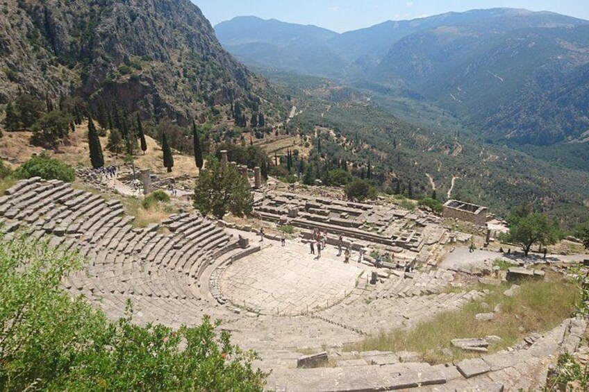An ancient amphitheater surrounded by mountains and trees. 4