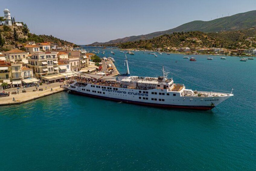 A large cruise ship docked at a port with a town in the background. 4
