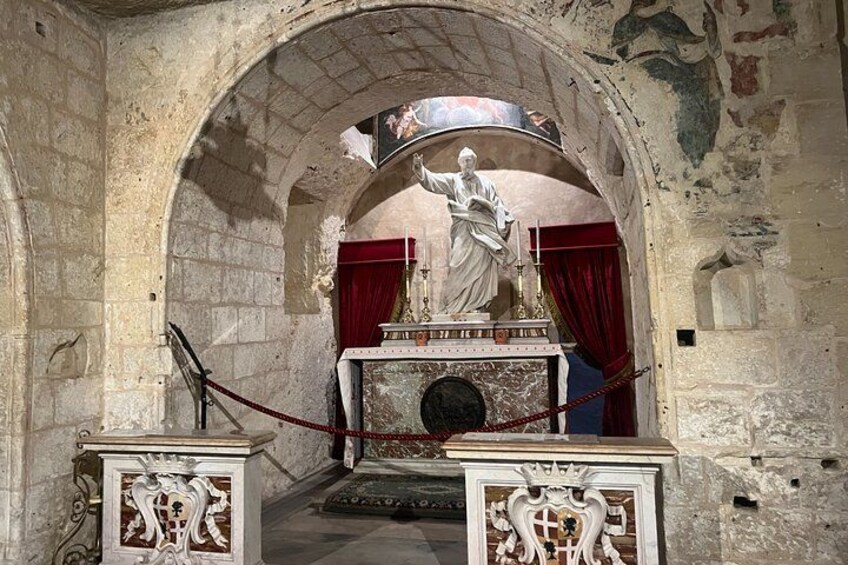 An arched doorway with a statue, red curtains, and ornate carvings. 3