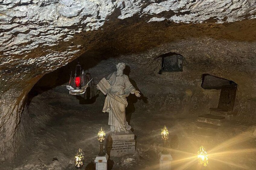 A cave with a statue, a lantern, and a plaque. 3