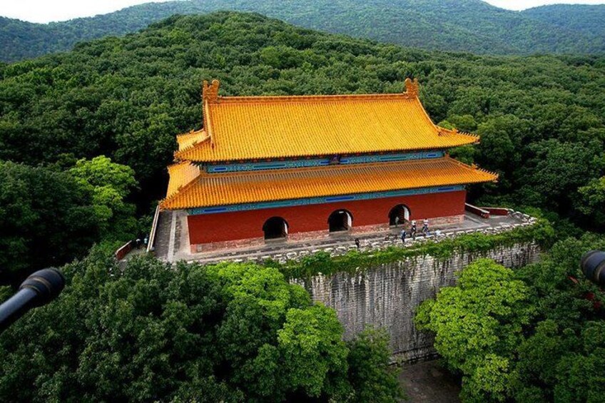 A traditional Chinese building with a yellow roof, surrounded by lush greenery and hills. 3