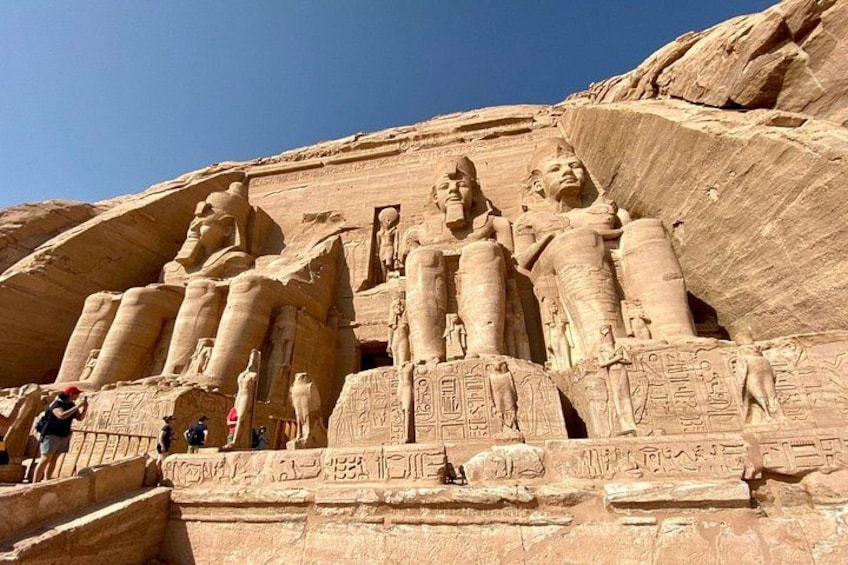 A large rock formation with ancient Egyptian hieroglyphs and statues. 3