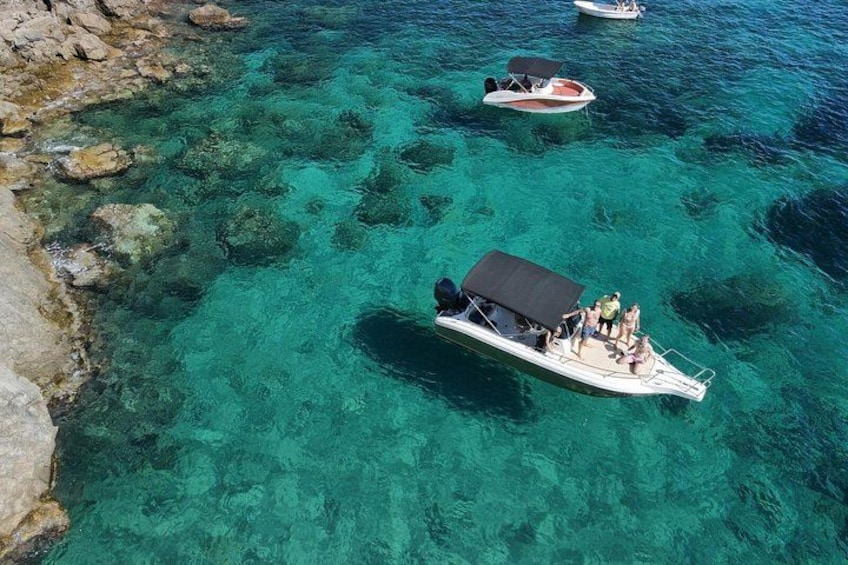 A clear turquoise sea with boats. 1
