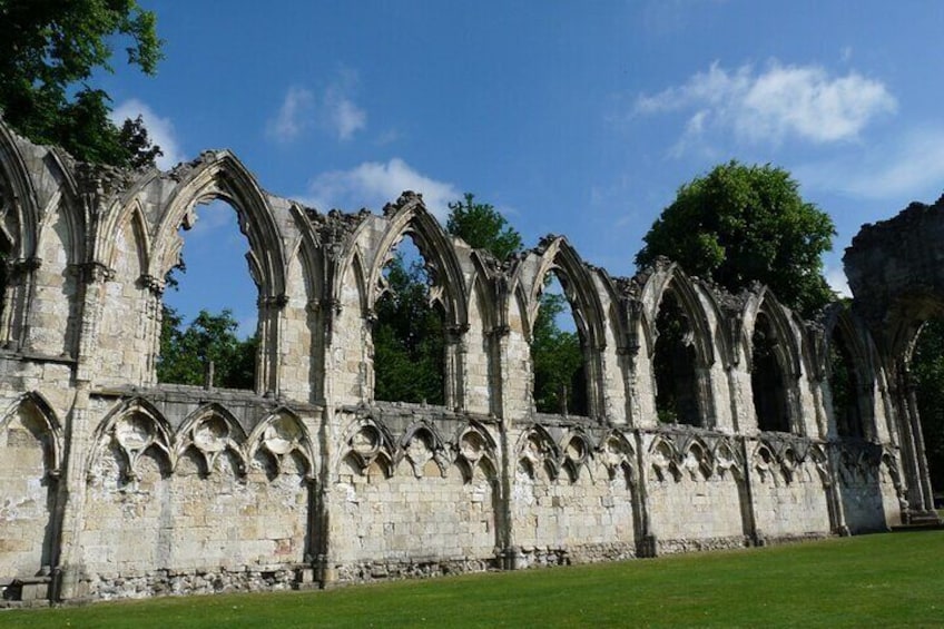 Ruinas de una estructura de piedra de estilo gótico, con arcos apuntados y detallada ornamentación pétrea. 5