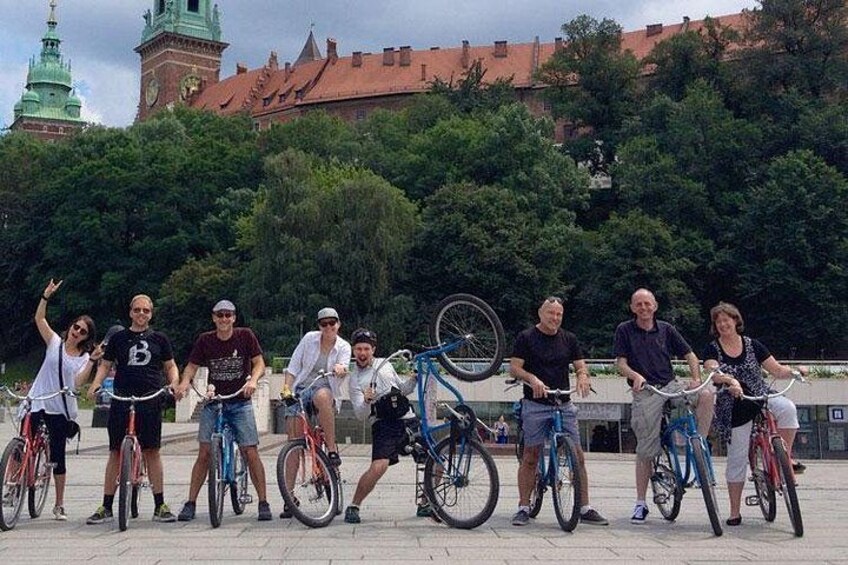 Un groupe de personnes à vélo, dans un cadre extérieur, avec un bâtiment historique en arrière-plan. 4