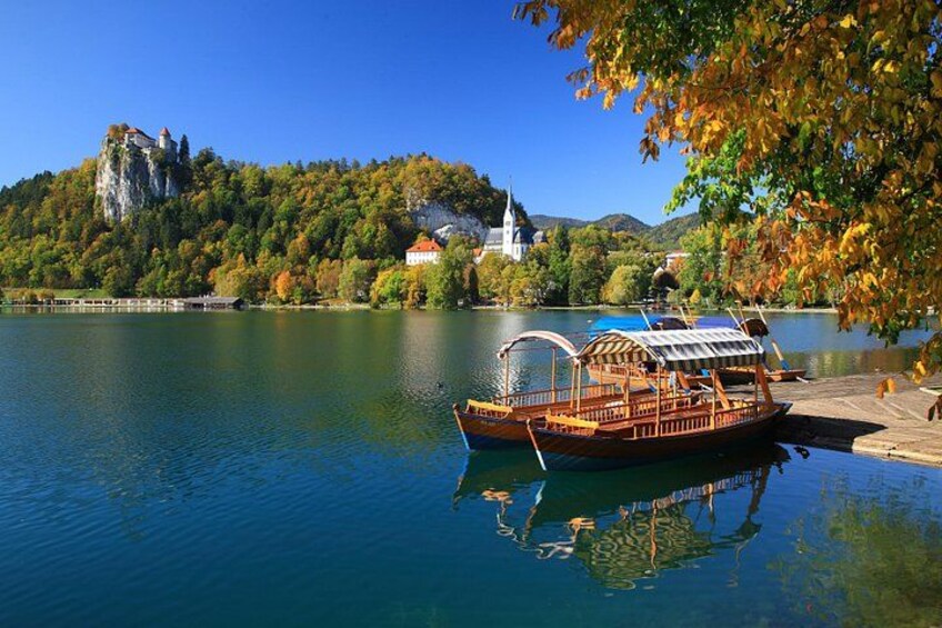 A boat docked near a lake with a castle and church in the background. 4