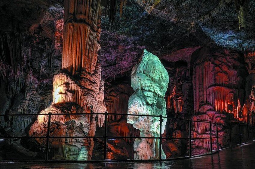 A cave with illuminated stalactites and a large, illuminated boulder. 3
