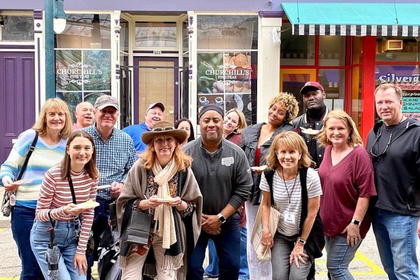 A group of people standing in front of a building with a sign that reads 'Churchill's.' 2