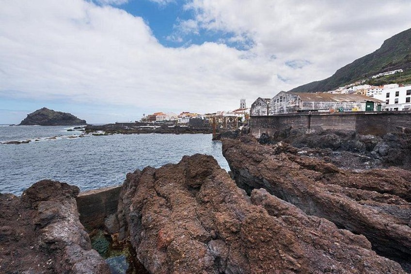 Rocky coastline, a bridge, and buildings in the background. 2