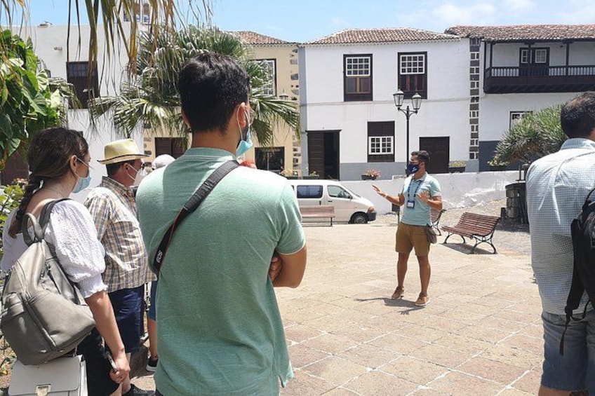 A group of people standing in a courtyard with a building in the background. 3