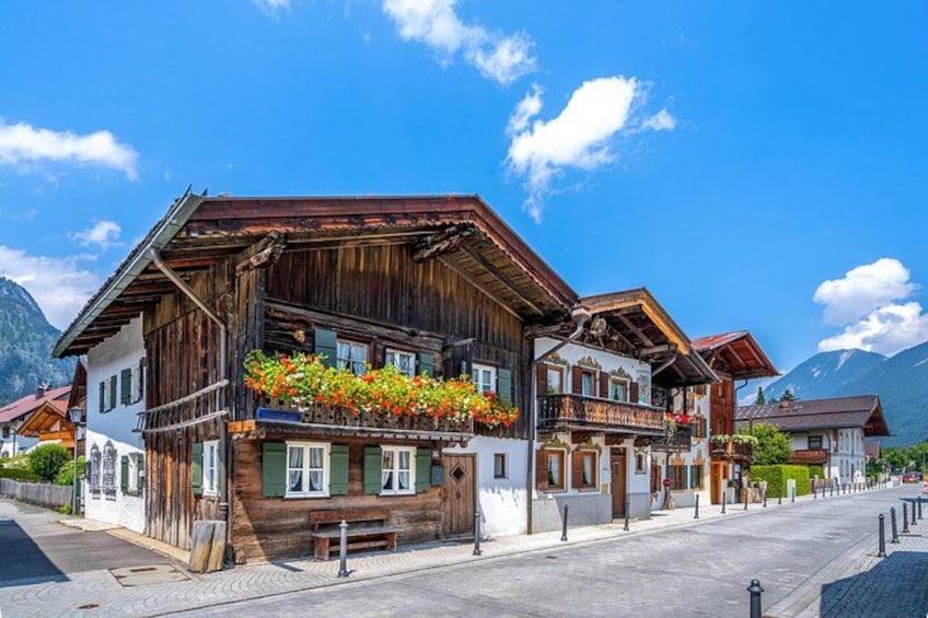 A traditional wooden chalet with balconies, surrounded by a mountain landscape. 5