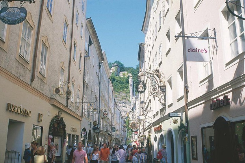 Une rue animée bordée de bâtiments historiques, une enseigne indiquant le magasin « Claire’s » et un magasin « Denkstein ». 4