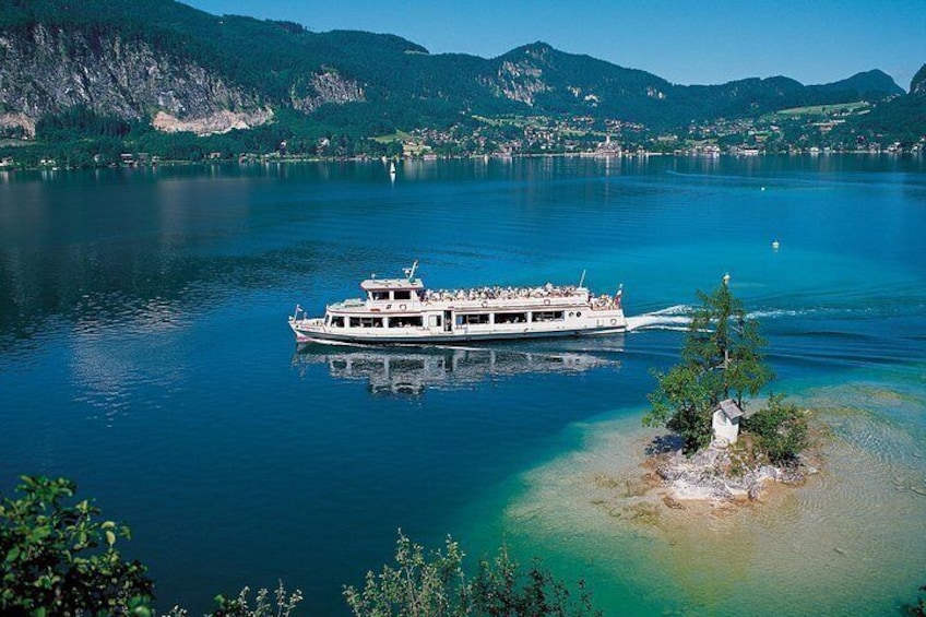 A boat on a calm lake surrounded by mountains. 4