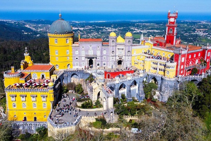 A colorful historic castle with multiple towers and a bridge. 1