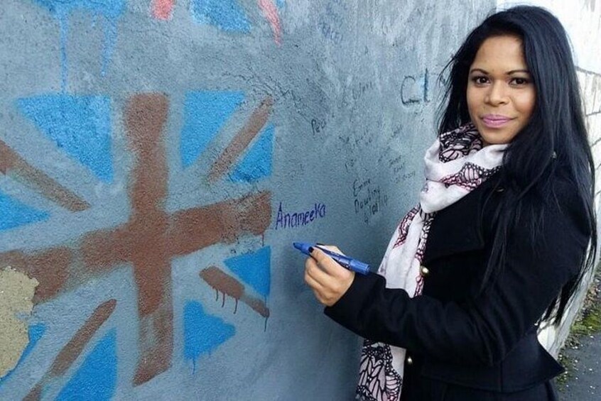 Une personne se tient devant un mur sur lequel est peint un drapeau Union Jack. 3