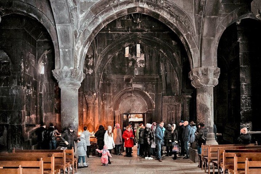 A group of people inside a cathedral with high arched ceilings and stone columns. 3