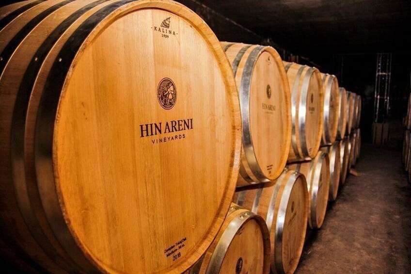 Wooden wine barrels stacked in a warehouse. 5