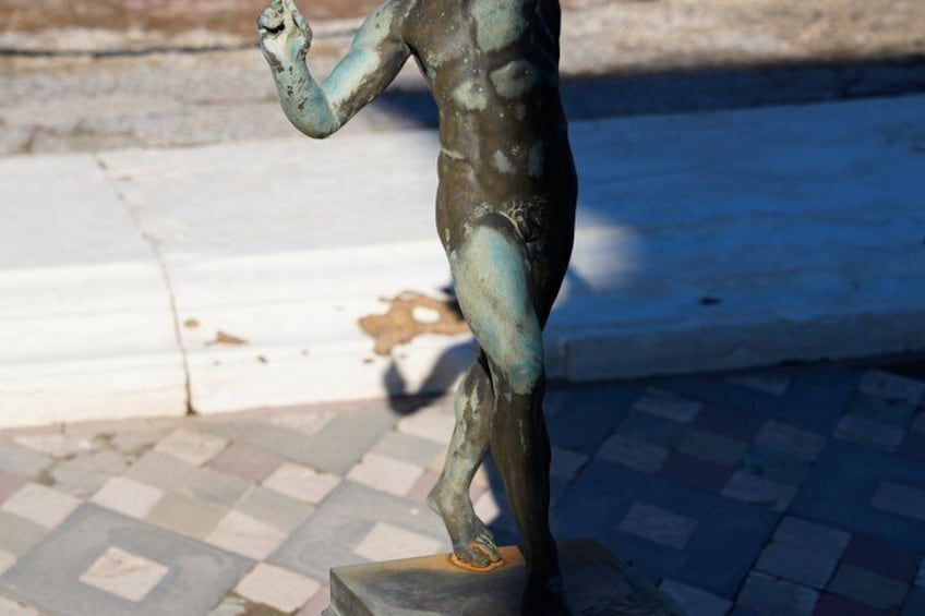 Eine Bronzestatue einer stehenden Person auf einem Sockel. 3