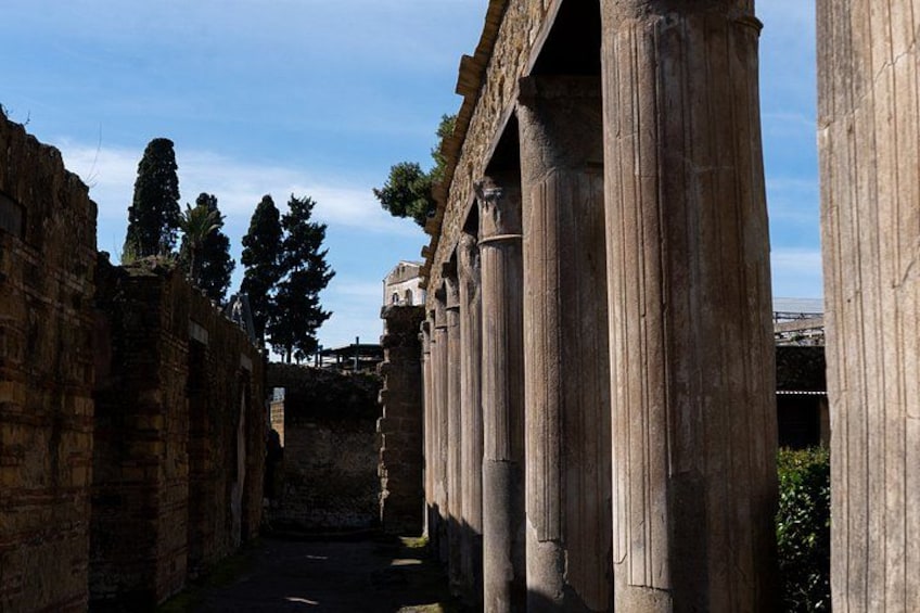 Columnas de piedra antiguas, un estrecho pasadizo y un edificio distante. 3