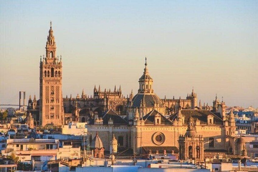 Un paisaje urbano histórico con arquitectura gótica destacada, incluyendo un campanario alto y una catedral con un ventanal circular grande. 4