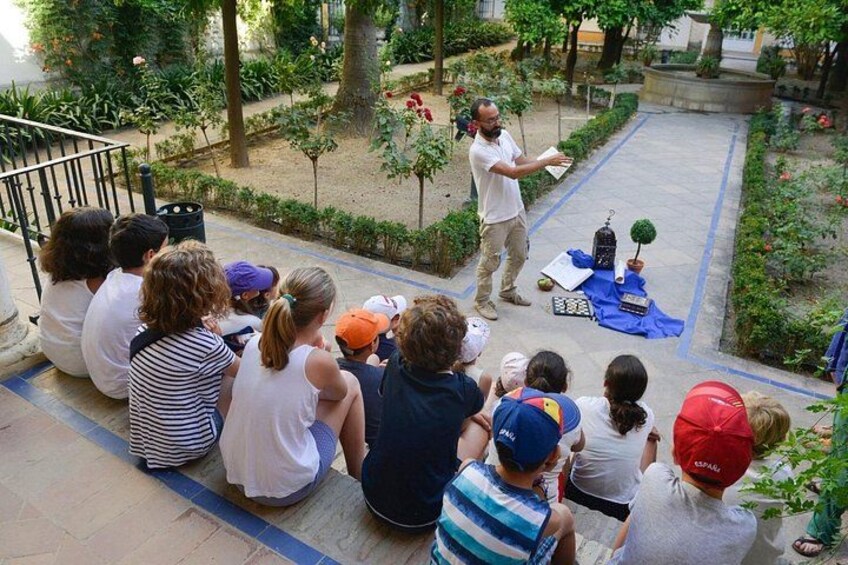 A group of people sitting on steps, watching a person standing on the ground. 1