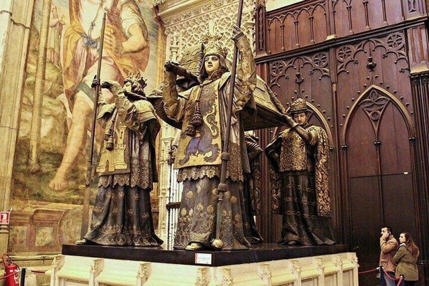 Una estatua religiosa con detalles intrincados y un mural grande al fondo. 2