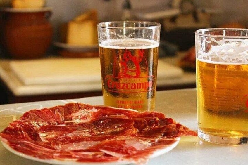 Une assiette de viande tranchée, deux verres de bière et un arrière-plan flou. 2