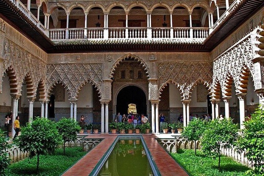 Une cour intérieure agrémentée d’arcades, d’une fontaine et de plantes en pot. 3