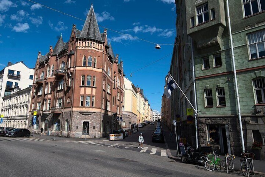 En gade med en historisk bygning, et fodgængerfelt og cykler parkeret langs fortovet. 5