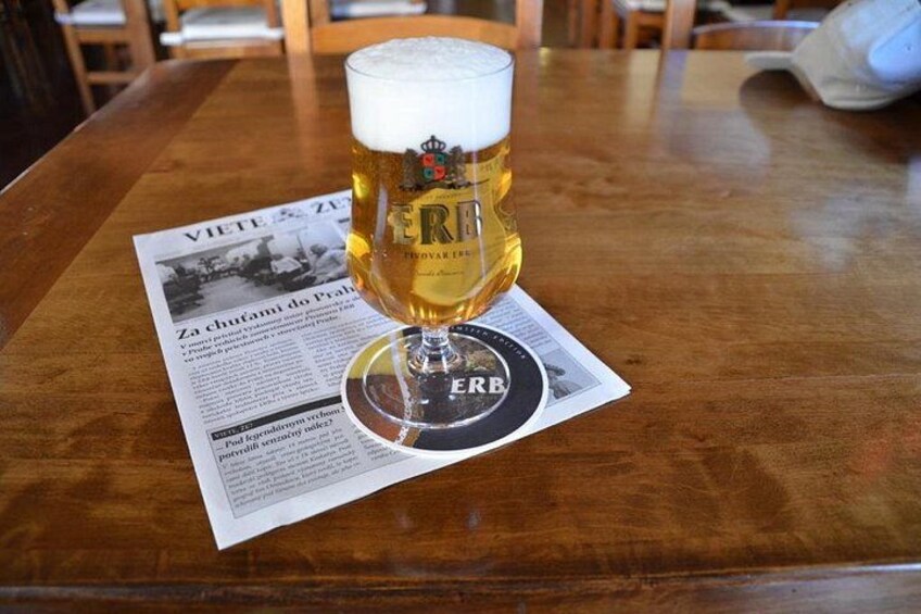 Un vaso de cerveza sobre un posavasos, con un periódico debajo. 5