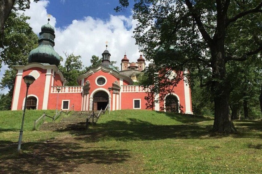 Una iglesia roja con una cúpula verde y un campanario. 2