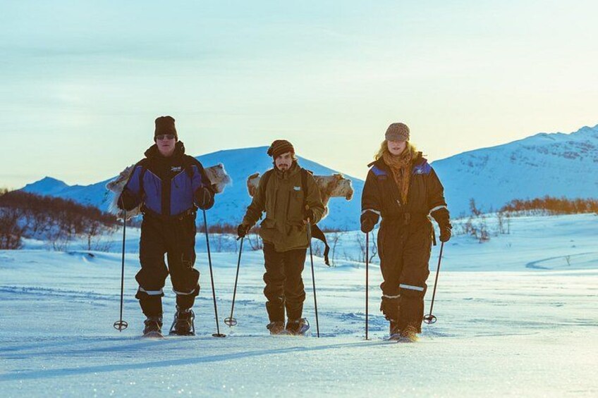 Trois personnes pratiquent le ski de fond dans un paysage enneigé, avec des montagnes en arrière-plan. 5