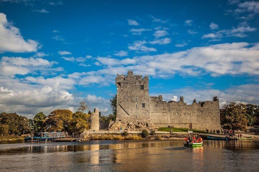 A historic castle by a river with a boat in the foreground. 1