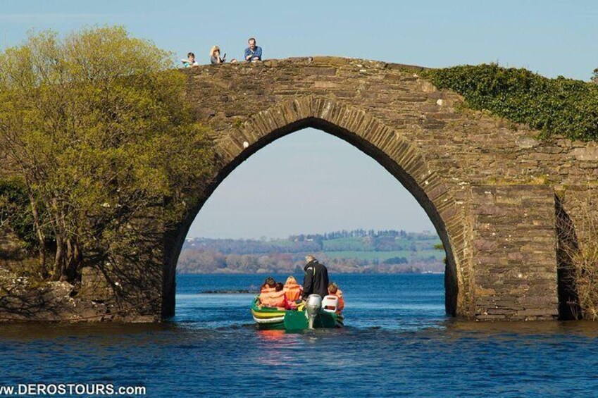 Un pont de pierre enjambant une étendue d’eau, avec des personnes et un bateau. 4