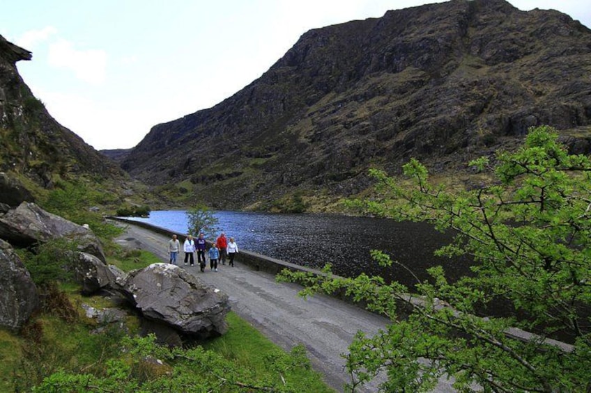 A group of people walking on a bridge over a river in a mountainous area. 5