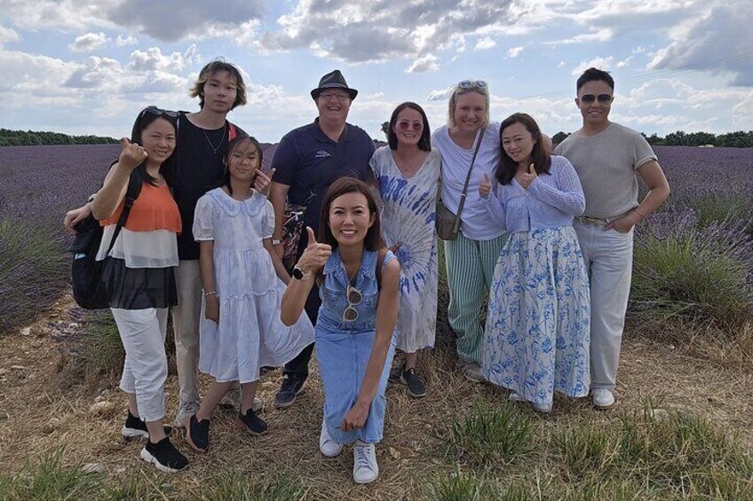A group of people standing in a field of lavender. 1