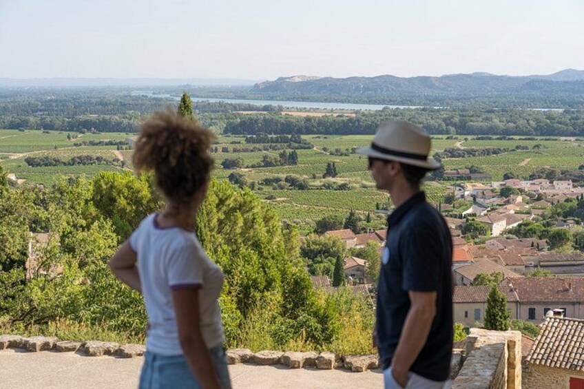 Two people overlooking a rural landscape with fields, trees, and a distant town. 2