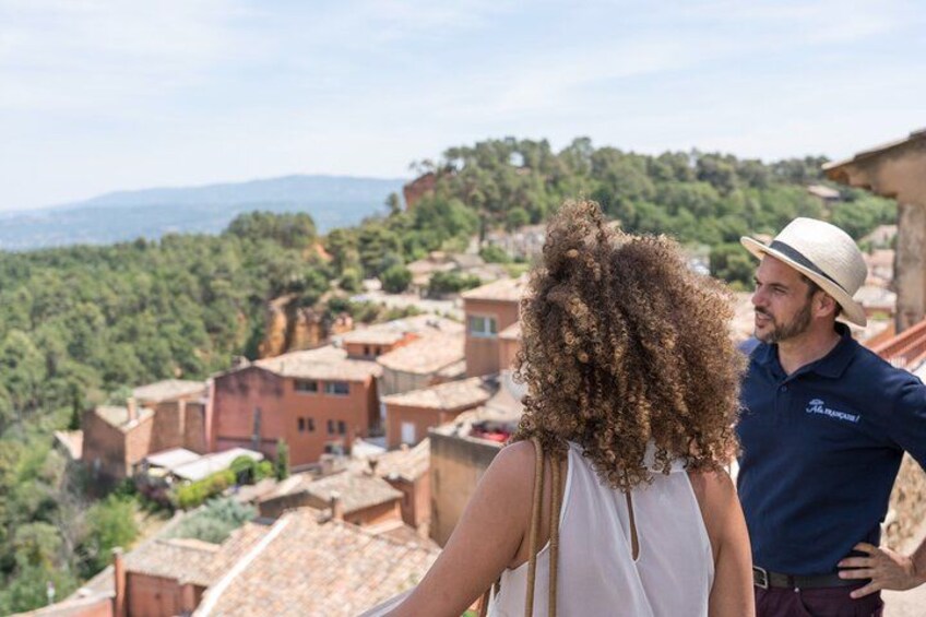 A couple overlooking a hillside village with terracotta-roofed buildings. 5