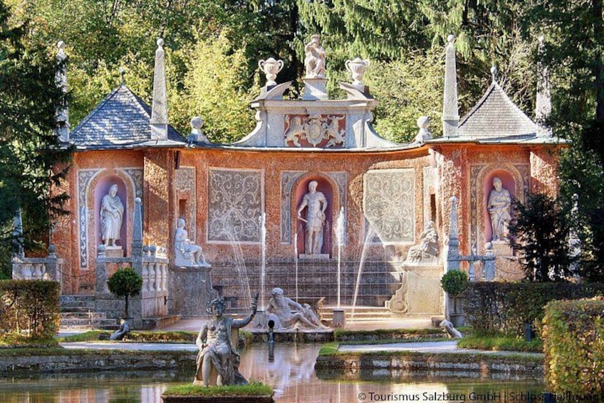 Ein klassizistisches Gebäude mit Statuen, einem Brunnen und einem Teich. 4