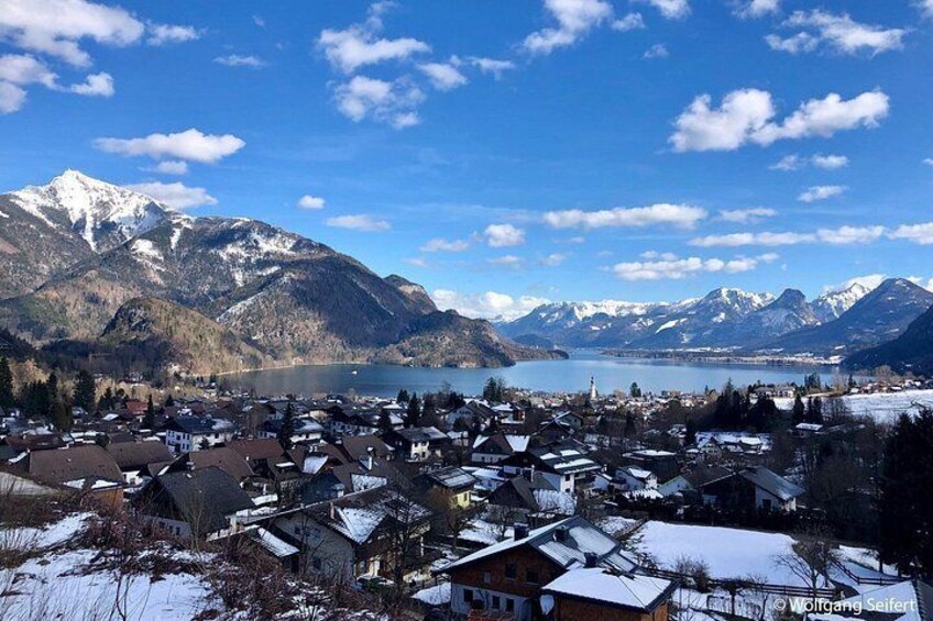 A snow-covered village with mountains and a lake in the background. 3