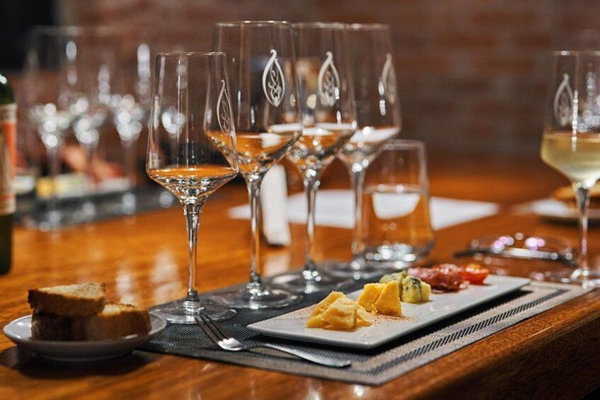 A bar setting with glasses of wine and a plate of food. 5
