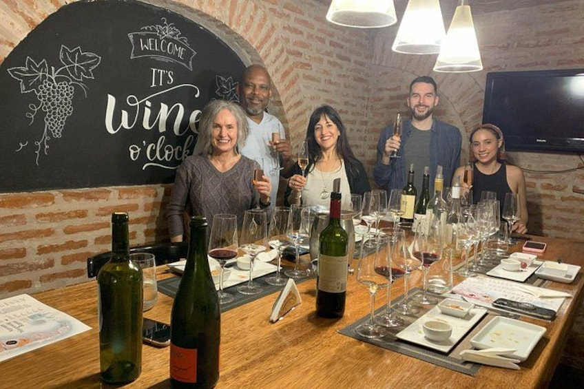 A wine tasting event with a chalkboard sign, wine bottles, glasses, and a brick wall. 2