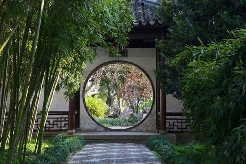 En traditionel japansk have med et rundt udkigsvindue, bambus og en sti af sten. 4