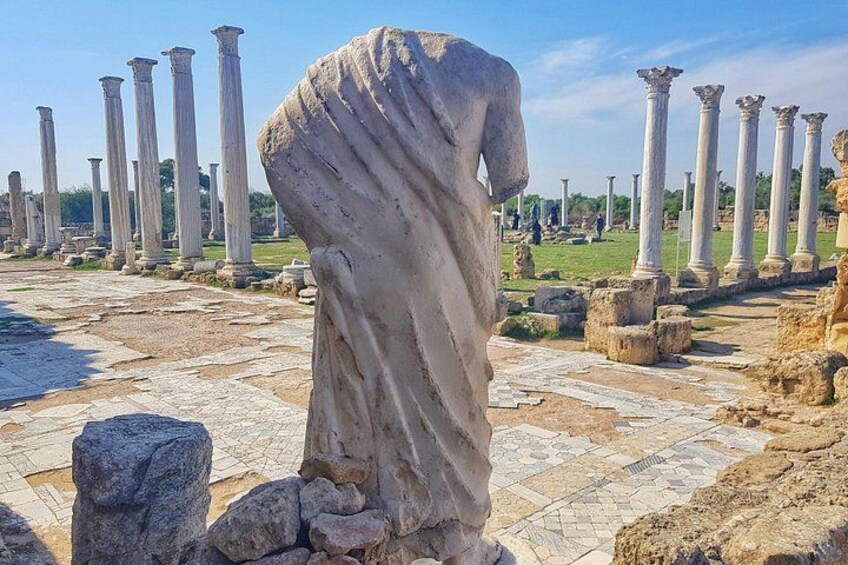 Ancient ruins with columns and a statue. 1