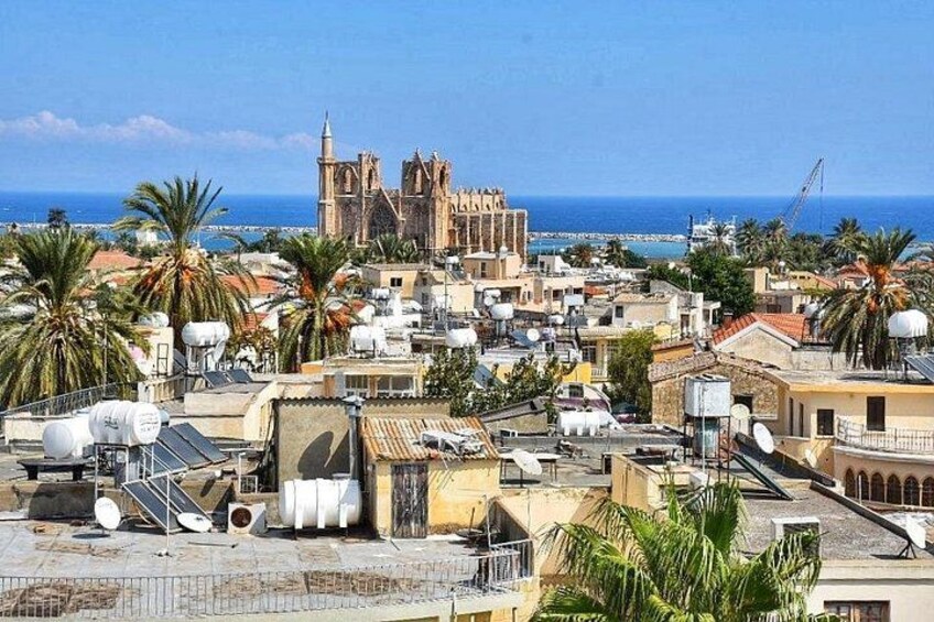 Paesaggio costiero con una cattedrale imponente, palme e edifici residenziali. 2