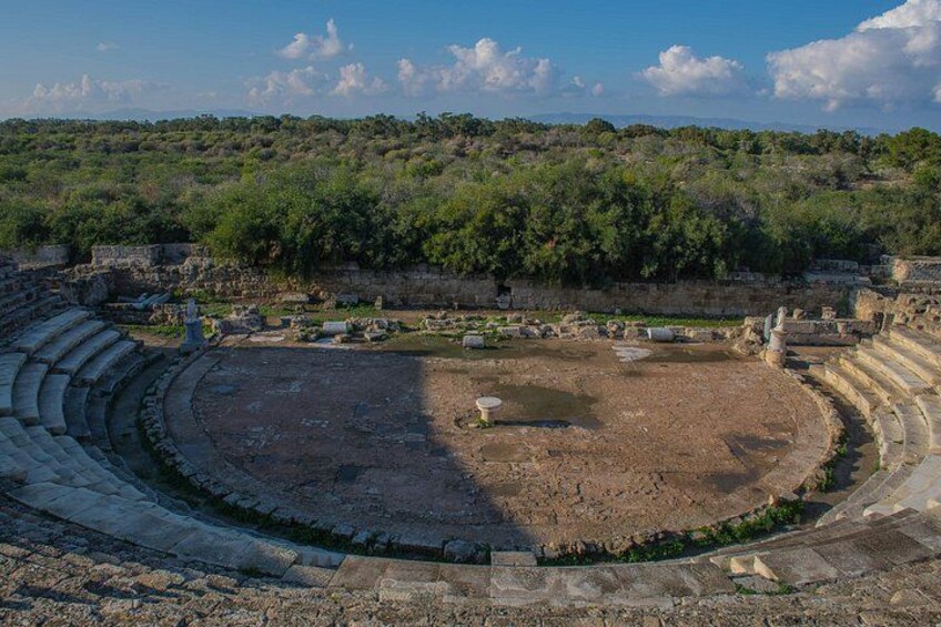 An ancient amphitheater with stone seating and a central stage area. 4