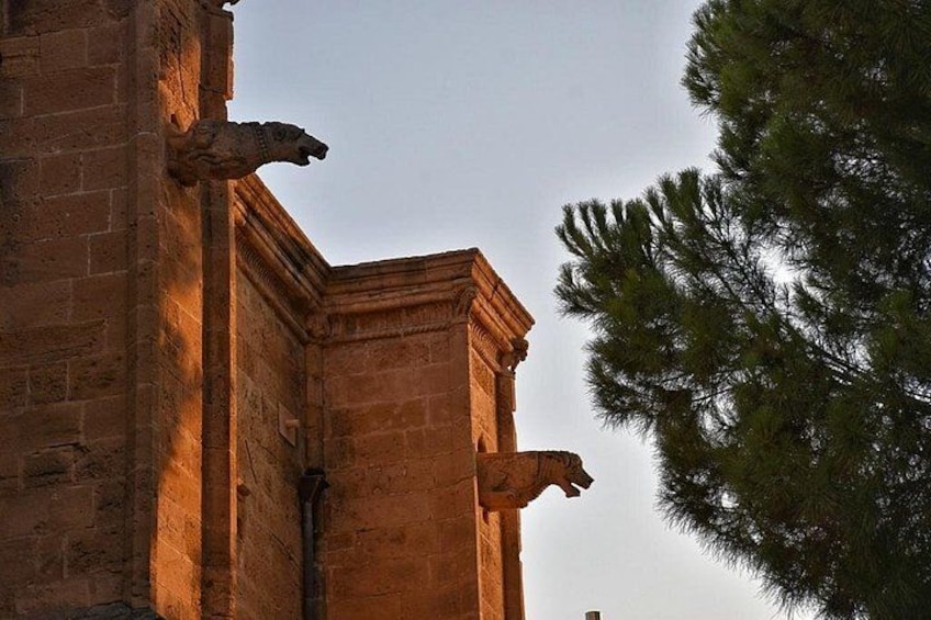 Un edificio in pietra con due statue di leoni agli angoli. 5