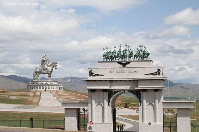 Un monumento con una estatua ecuestre y un gran arco con inscripciones. 1